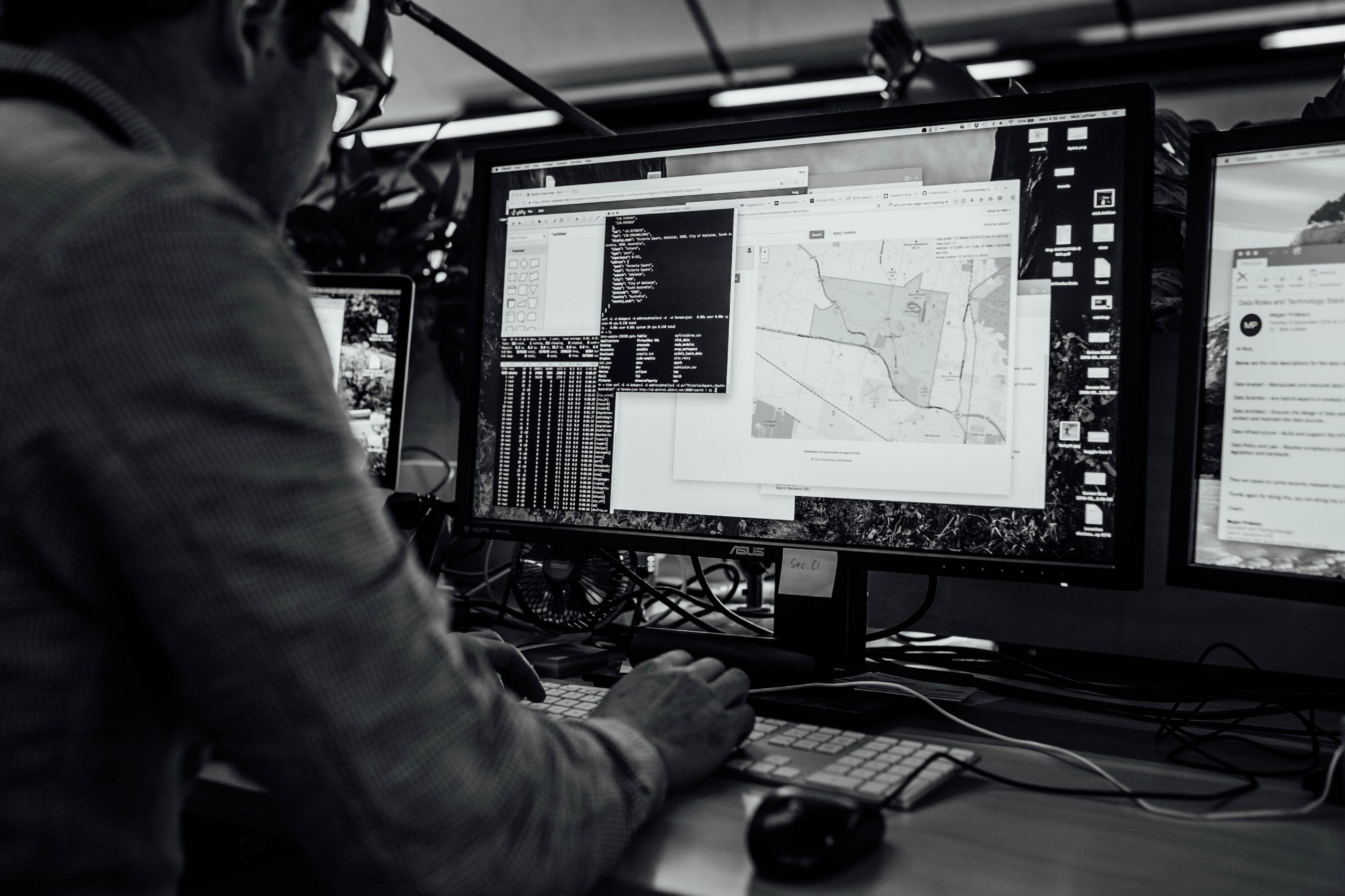 Fivecast - Black and White image of a person working at a computer in the defence industry