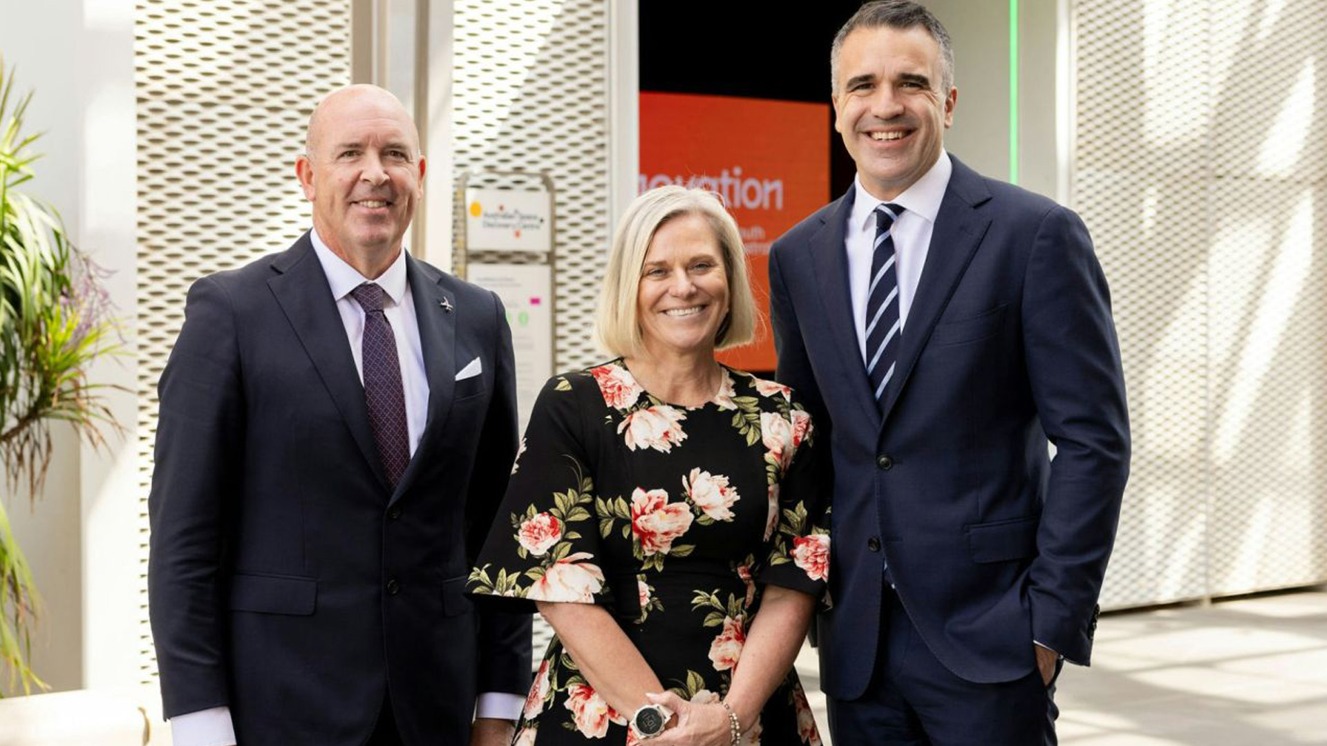 Three people standing out the front of the Lot Fourteen Innovation District in Adelaide ahead of an announcement